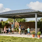 Moderne freistehende Terrassenüberdachung in lebendigem Garten mit Familie, ideal für sonnige Tage.